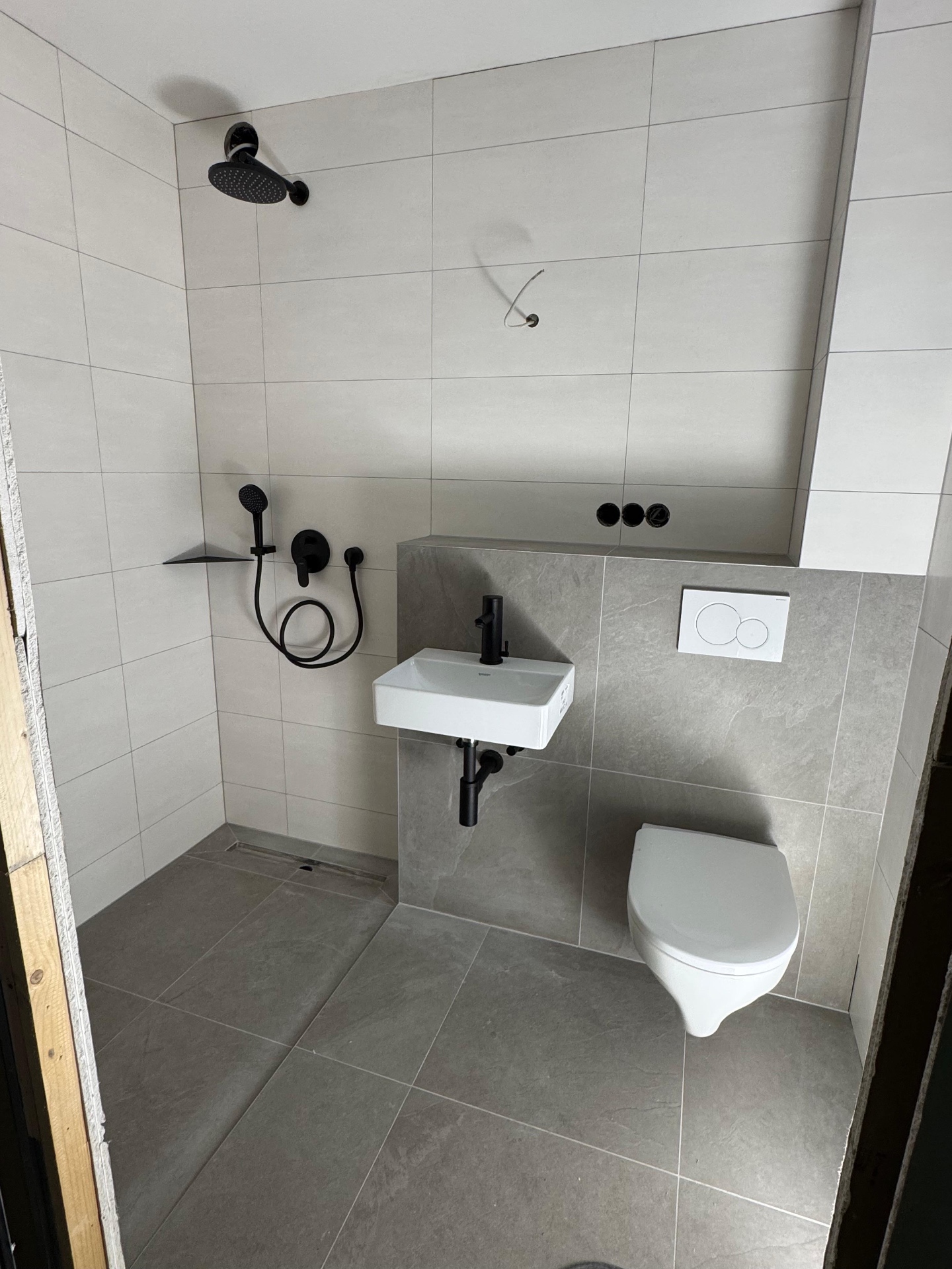 Walk-in-Dusche mit wandhängendem WC, matt-schwarze Armaturen